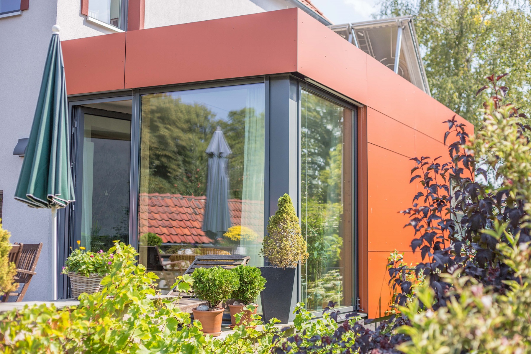 Eckverglasung des orangefarbenen Anbaus am Reihenhaus in Hildesheim
